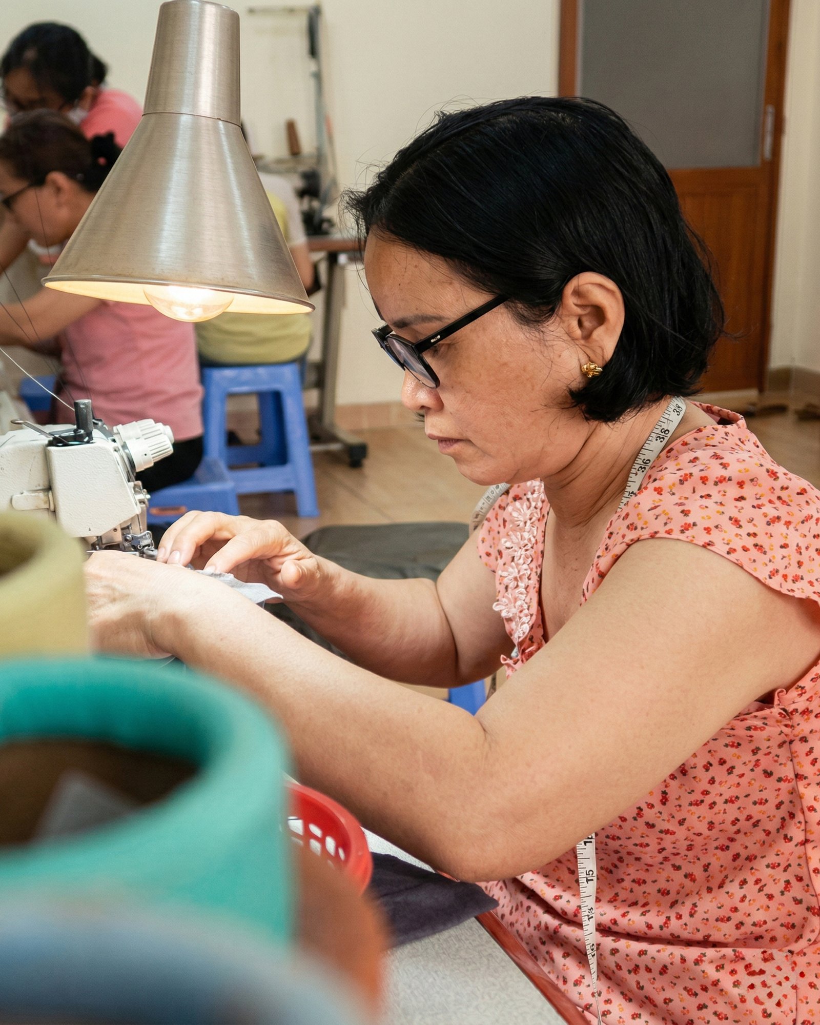 A DINS artisan sewing a garment by hand