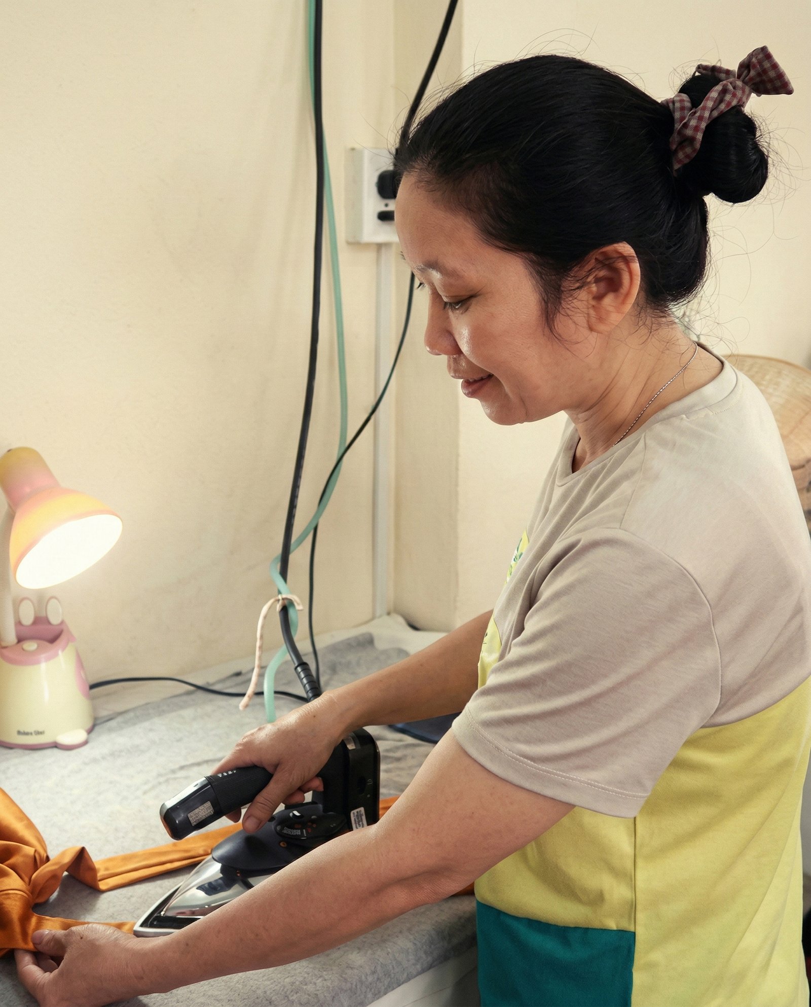 A DINS artisan carefully pressing fabric